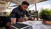 Black male athlete planning recovery meals at kitchen table