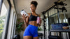 Fit Black woman reading meal replacement label in kitchen