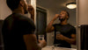 Black male athlete taking night supplement capsule