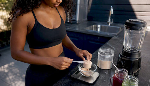 Hands measuring protein powder on kitchen scale