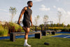Black athlete stretching sore leg muscles in gym