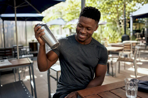 Black man shaking protein shaker cup