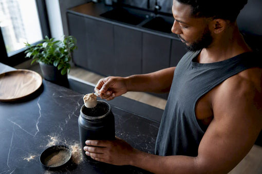 Man scooping protein powder in modern kitchen