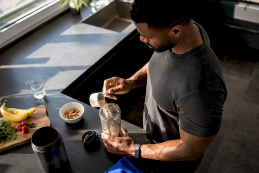 Black man pouring protein powder into shaker