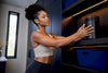 Black woman storing protein powder in pantry