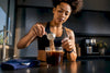 Fit Black woman preparing protein coffee